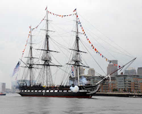 USS Constitution docked in Boston, showcasing her wooden hull and historic design